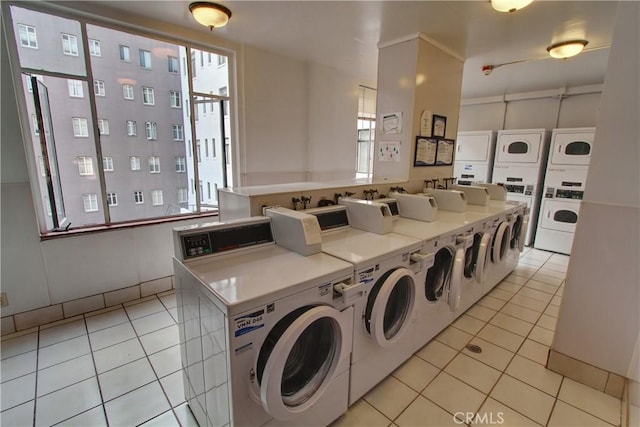community laundry room with separate washer and dryer, stacked washer and clothes dryer, plenty of natural light, and light tile patterned floors