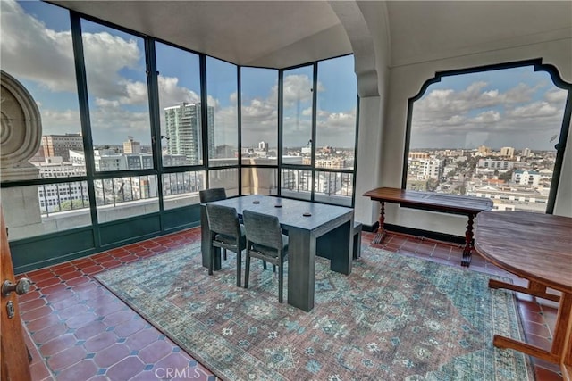 sunroom / solarium featuring tile patterned floors and a city view