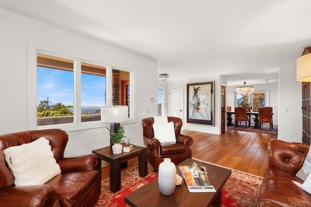 living room with hardwood / wood-style floors and a notable chandelier