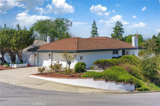 29461 Via Valverde, Laguna Niguel, CA 92677 - view of side of home with concrete driveway, a chimney, a tiled roof, and a garage