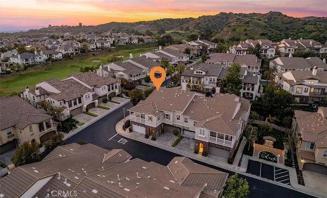 aerial view at dusk featuring a residential view and a mountain view