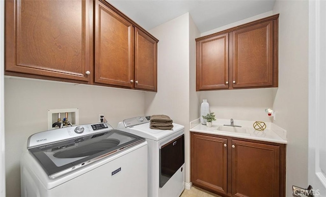 laundry room with a sink, washing machine and dryer, and cabinet space