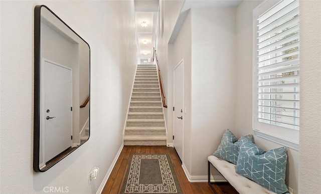 doorway to outside featuring baseboards, stairs, and wood finished floors