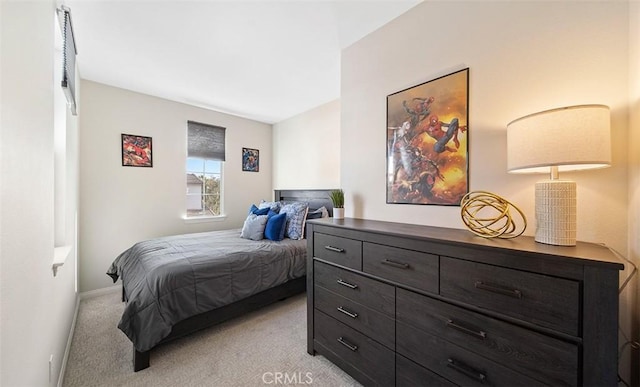 bedroom featuring baseboards and light carpet