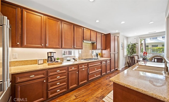 kitchen featuring light stone countertops, a sink, stainless steel appliances, recessed lighting, and dark wood-type flooring