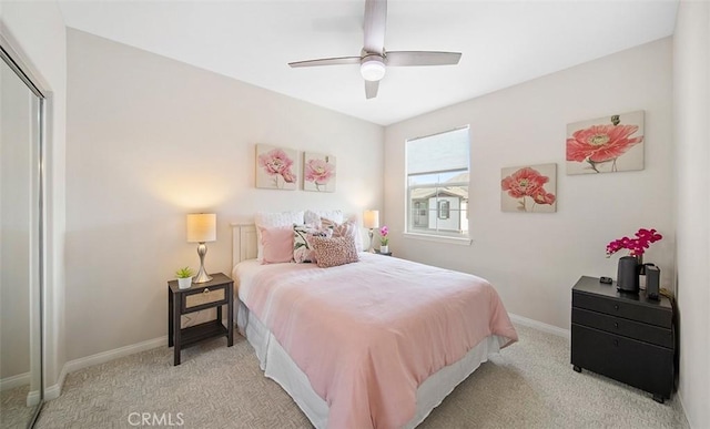 bedroom with baseboards, a ceiling fan, a closet, and light carpet