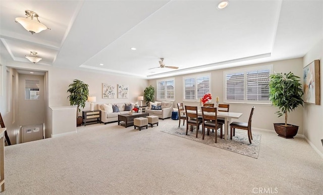 carpeted dining space featuring a ceiling fan, a tray ceiling, recessed lighting, and baseboards