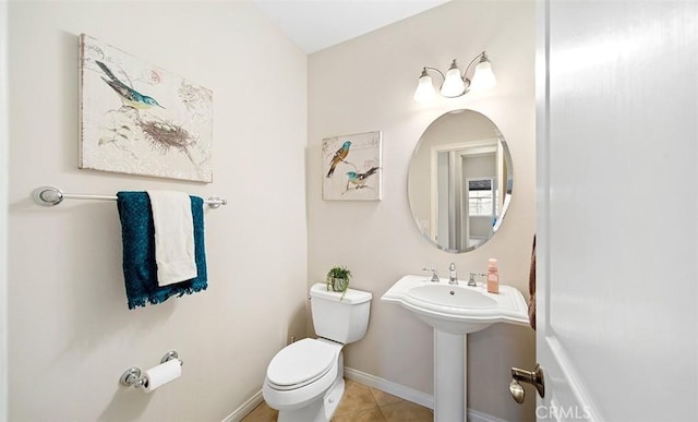 bathroom featuring tile patterned floors, baseboards, and toilet