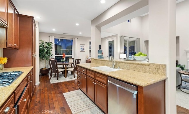 kitchen featuring light stone countertops, dark wood-style floors, recessed lighting, a sink, and appliances with stainless steel finishes