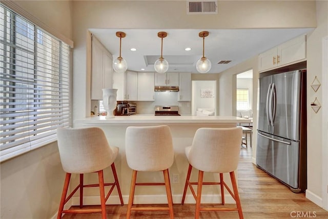 kitchen with visible vents, a peninsula, a wealth of natural light, and stainless steel appliances