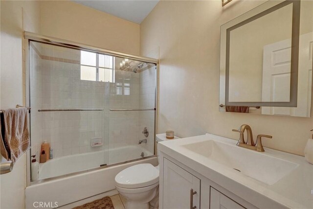 full bathroom featuring vanity, enclosed tub / shower combo, and toilet