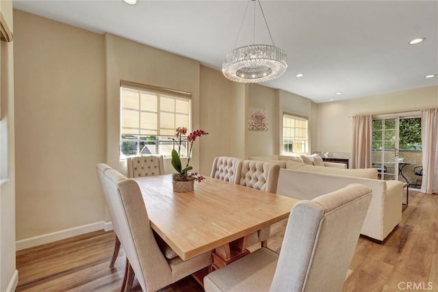 dining room with recessed lighting, baseboards, an inviting chandelier, and light wood-style floors