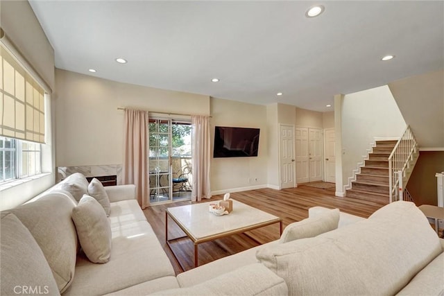 living area featuring stairway, baseboards, recessed lighting, and wood finished floors