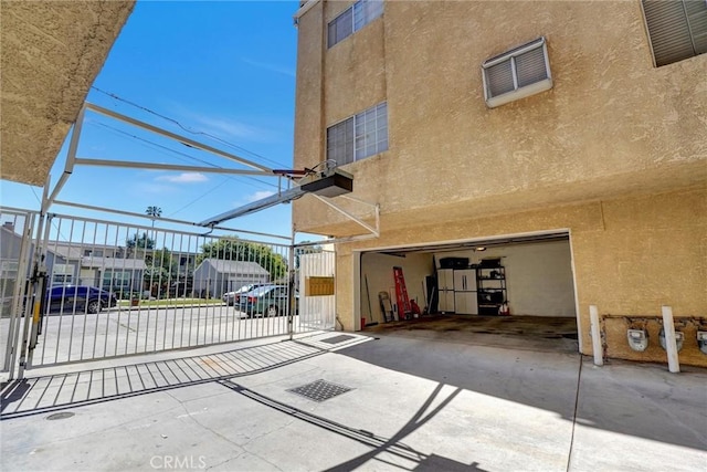 view of patio / terrace featuring a garage, visible vents, and a gate