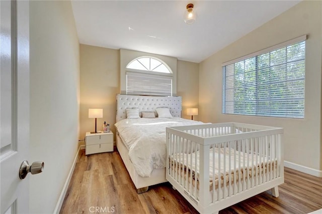 bedroom with baseboards and wood finished floors