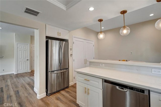 kitchen with visible vents, crown molding, appliances with stainless steel finishes, light wood-type flooring, and white cabinetry