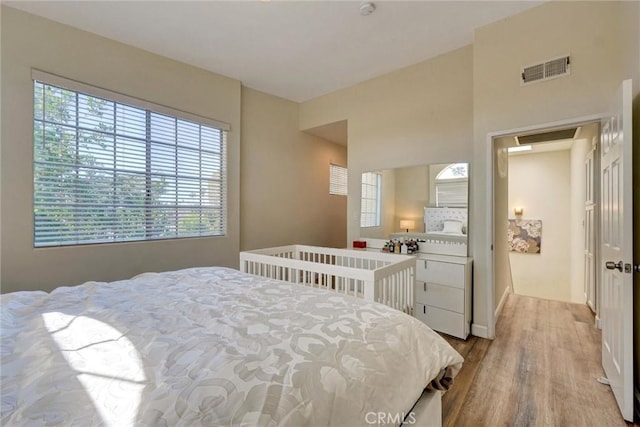 bedroom with baseboards, visible vents, and light wood-style floors