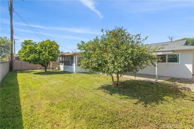 view of yard with a sunroom, a fenced backyard, and a patio area