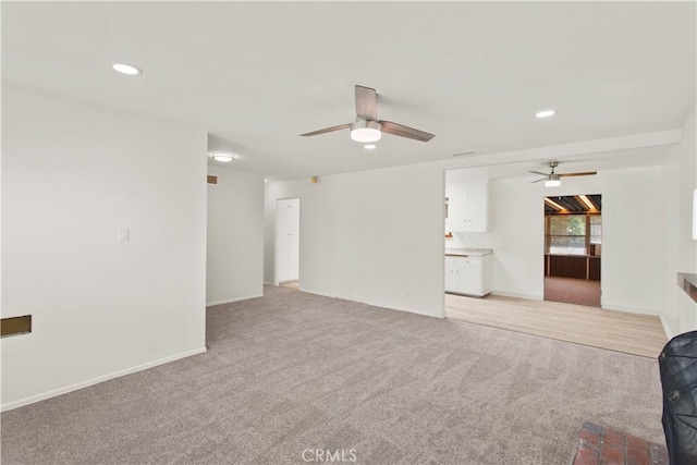 unfurnished living room featuring baseboards, recessed lighting, light colored carpet, and a ceiling fan