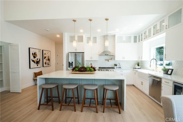 1933 Fanwood Ave, Long Beach, CA 90815 - kitchen with appliances with stainless steel finishes, decorative backsplash, light wood finished floors, a kitchen island, and recessed lighting