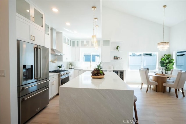 1933 Fanwood Ave, Long Beach, CA 90815 - kitchen featuring premium appliances, wall chimney range hood, a chandelier, tasteful backsplash, and light countertops