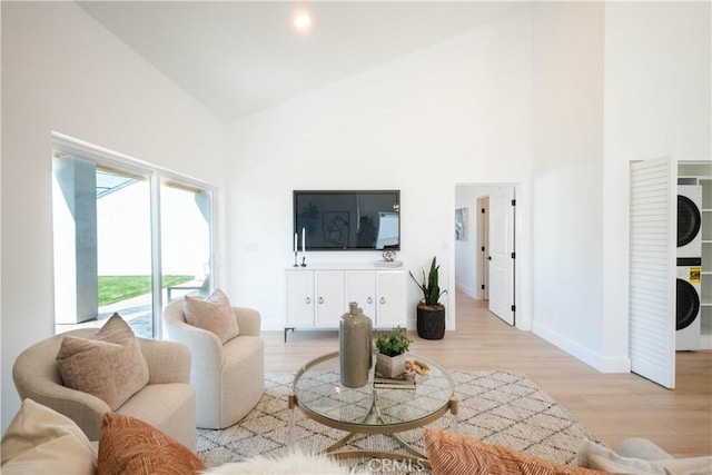 1933 Fanwood Ave, Long Beach, CA 90815 - living area featuring stacked washing machine and dryer, high vaulted ceiling, and light wood-style floors