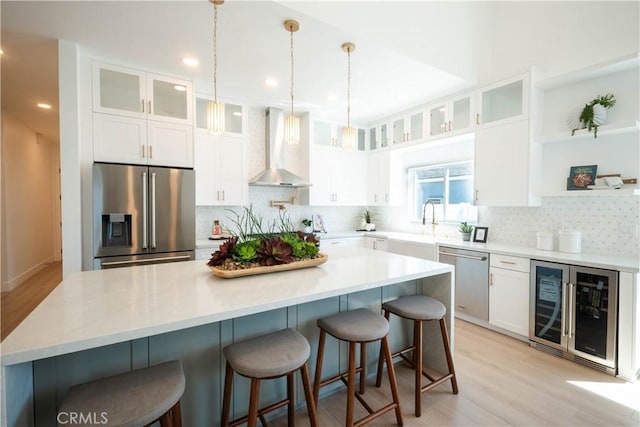 1933 Fanwood Ave, Long Beach, CA 90815 - kitchen with stainless steel appliances, wall chimney range hood, wine cooler, open shelves, and decorative backsplash