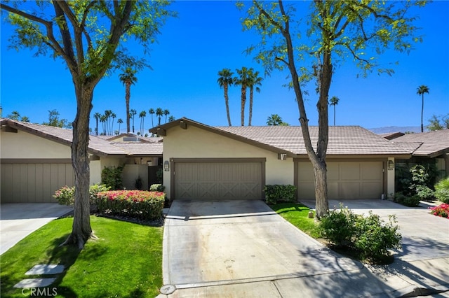 175 Bouquet Canyon Dr, Palm Desert, CA 92211 - view of front of house with driveway, an attached garage, a tile roof, a front lawn, and stucco siding