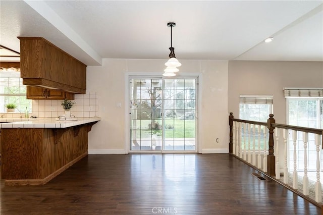 unfurnished dining area with dark wood-style floors, visible vents, and baseboards
