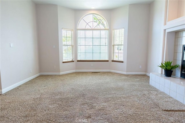unfurnished living room with baseboards and carpet