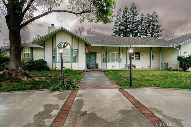 view of front of home with a chimney, a porch, and a front lawn