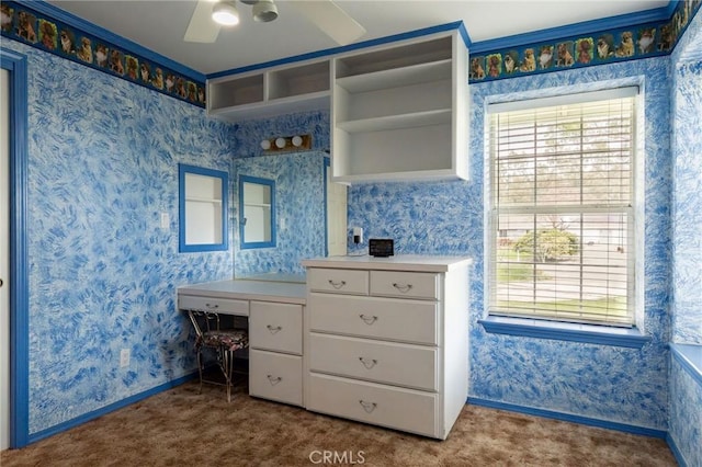 interior space featuring ceiling fan, vanity, wallpapered walls, and baseboards