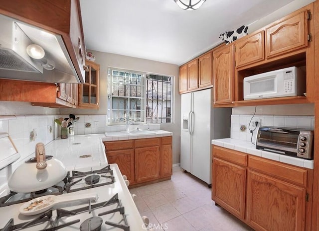 3654 7th Ave, Los Angeles, CA 90018 - kitchen with tile counters, a toaster, white appliances, tasteful backsplash, and under cabinet range hood