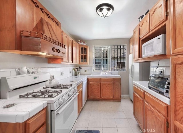 3654 7th Ave, Los Angeles, CA 90018 - kitchen featuring tile counters, white appliances, light tile patterned flooring, and tasteful backsplash