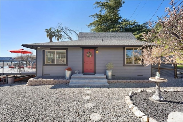 bungalow-style home with crawl space, fence, and a shingled roof