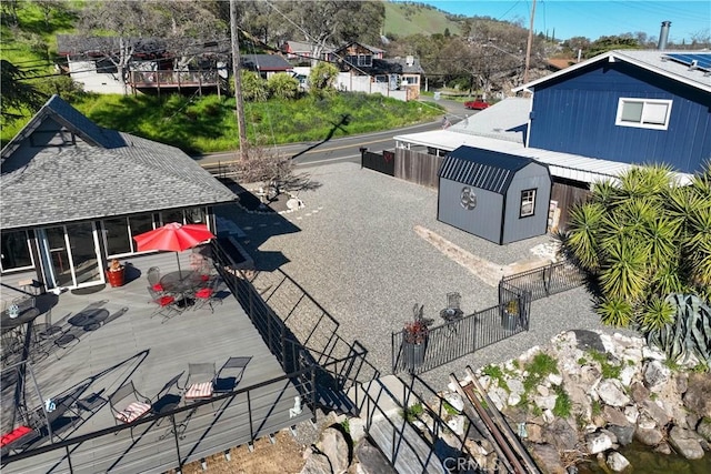 exterior space featuring an outbuilding, a shed, a fenced backyard, and a mountain view