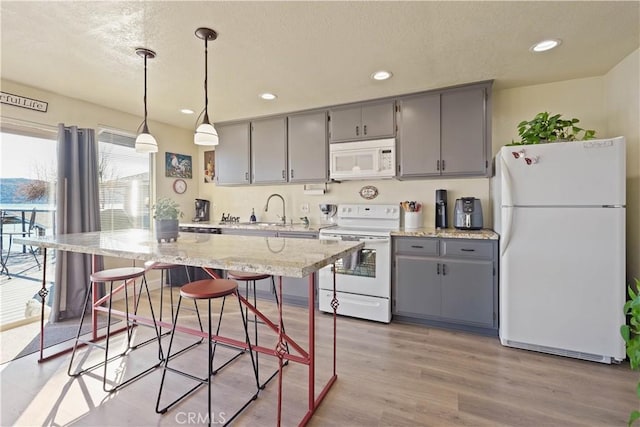 kitchen featuring gray cabinetry, white appliances, and recessed lighting