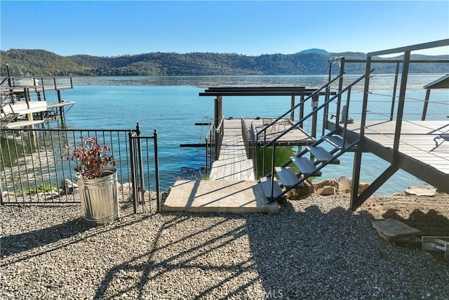 dock area featuring a water and mountain view and boat lift