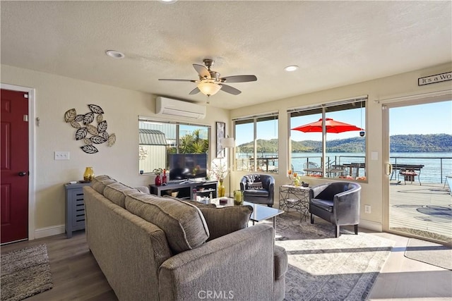 living room with baseboards, recessed lighting, a ceiling fan, wood finished floors, and a wall mounted AC
