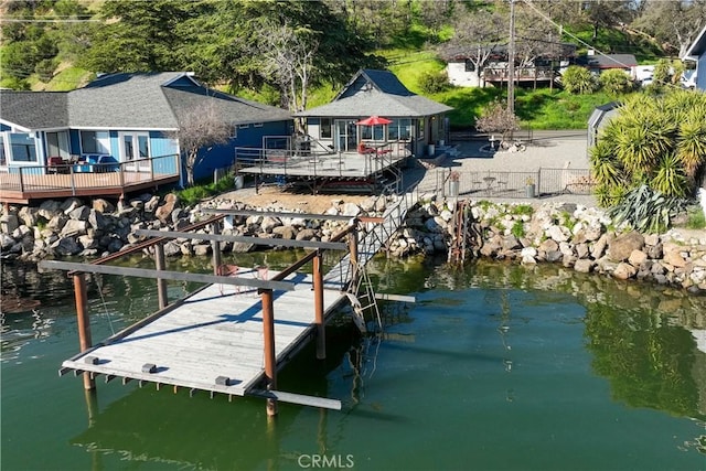 dock area featuring a deck with water view and fence