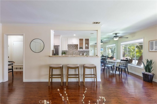 6 5th Pl, Long Beach, CA 90802 - kitchen featuring freestanding refrigerator, dark wood-style flooring, a kitchen bar, baseboards, and crown molding