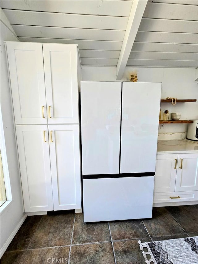 interior space with beamed ceiling and freestanding refrigerator