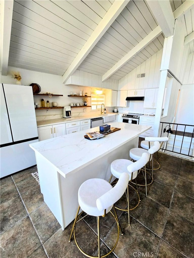 628 Rose Ln, Twin Peaks, CA 92391 - kitchen with white cabinets, appliances with stainless steel finishes, a kitchen breakfast bar, and vaulted ceiling with beams