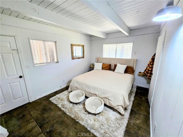 bedroom with beamed ceiling and baseboards