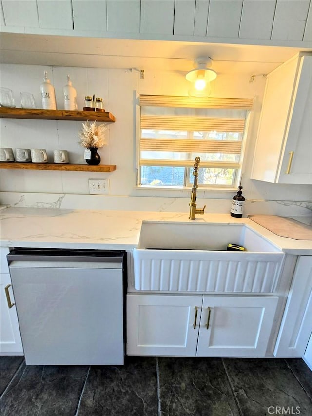 kitchen featuring white cabinetry, light stone countertops, dishwashing machine, and a sink