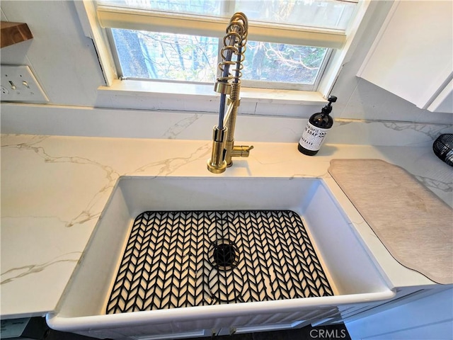 details featuring light stone countertops and a sink
