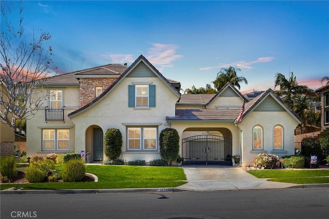 3274 Rural Ln, Corona, CA 92882 - view of front of property featuring a gate, concrete driveway, a front yard, a tile roof, and stucco siding