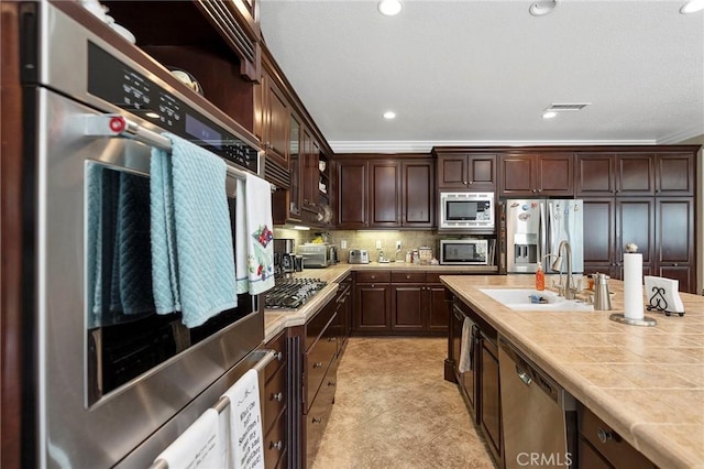 3274 Rural Ln, Corona, CA 92882 - kitchen featuring visible vents, stainless steel appliances, dark brown cabinetry, tile countertops, and a sink