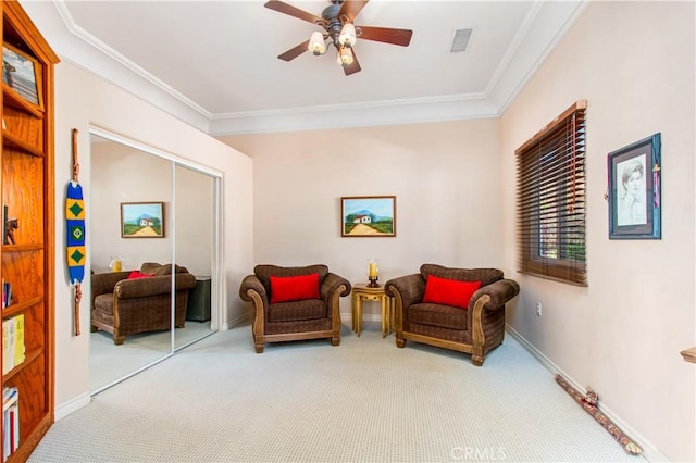sitting room with ornamental molding, ceiling fan, carpet, and visible vents