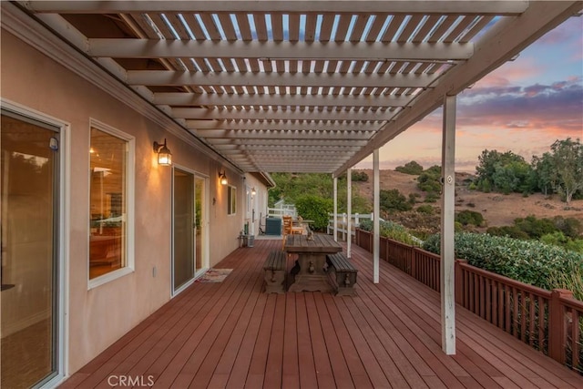 deck at dusk featuring a pergola and outdoor dining area